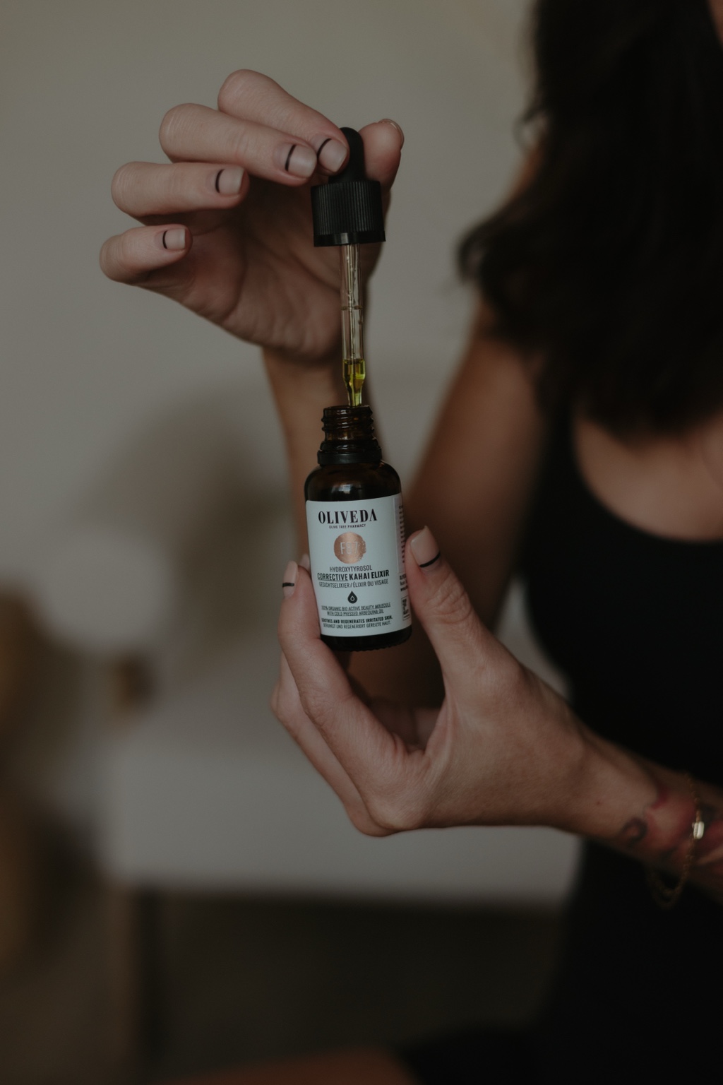 Alyssa holding an Oliveda serum dropper
