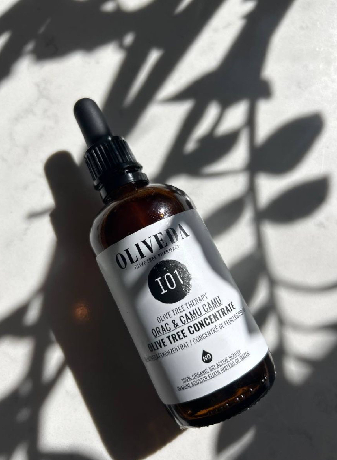 Oliveda bottle with botanical shadows